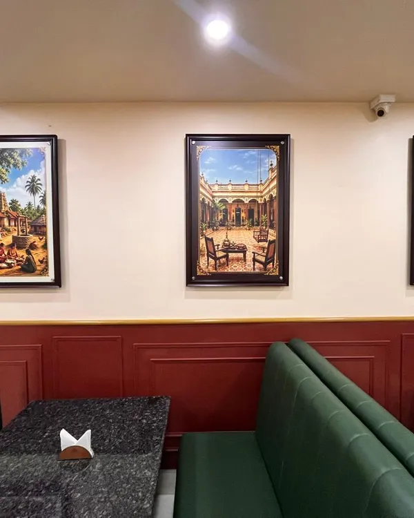 Green upholstered booths and framed artwork in the Egmore dining room