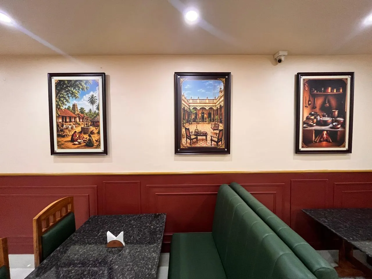 Green upholstered booths and framed artwork in the Egmore dining room
