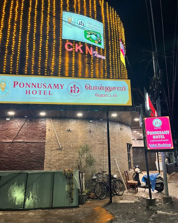 Exterior of the Egmore restaurant with hanging lights and Ponnusamy signage